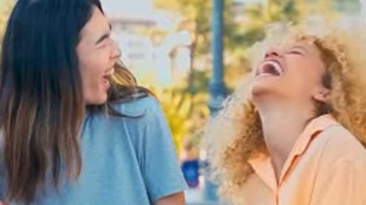 Still from a streaming TV spot: two students laughing outdoors